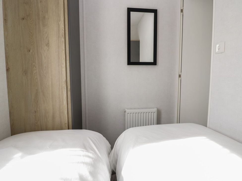 A bedroom with two beds and a mirror at Ash in Denny
