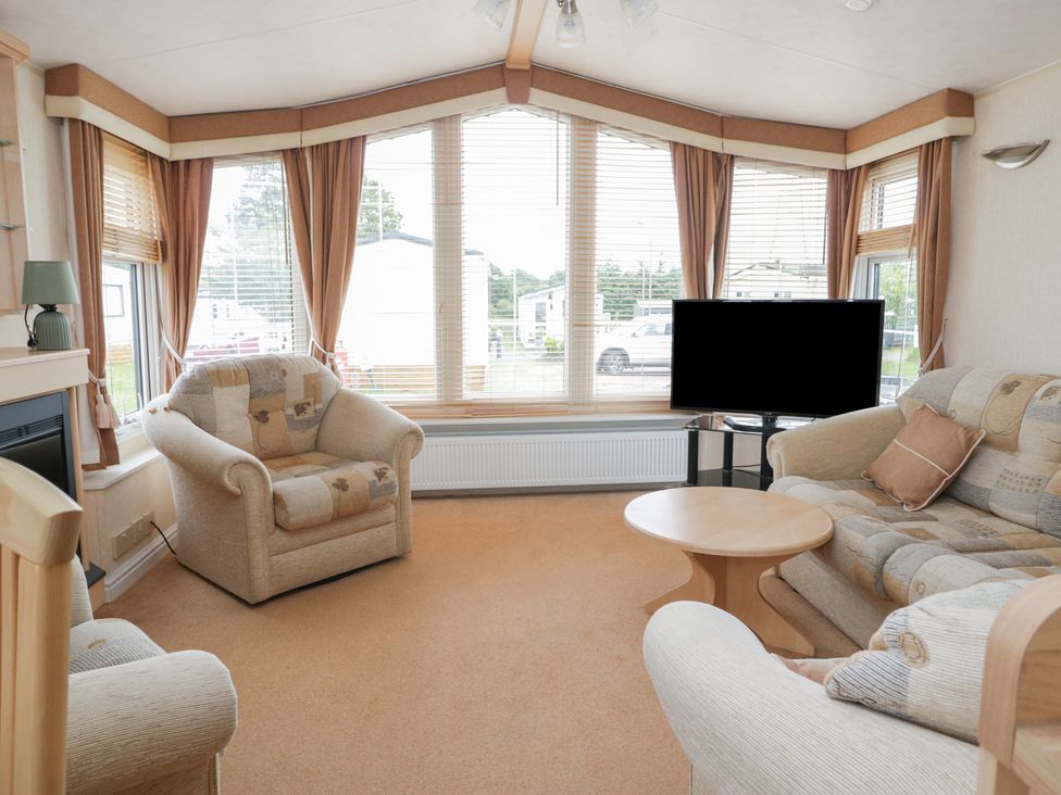 A living room with a sofa and television at Birch in Denny