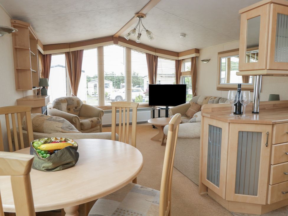 A living room with a dining table and sofa at Birch in Denny