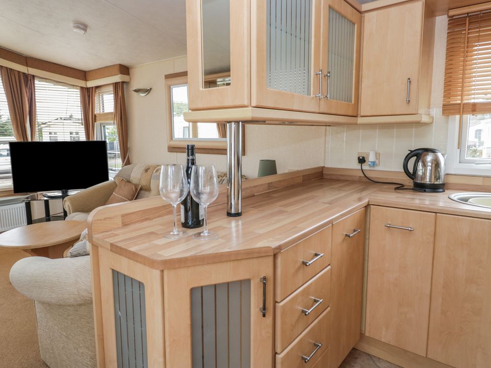 A kitchen with a countertop and television at Birch in Denny