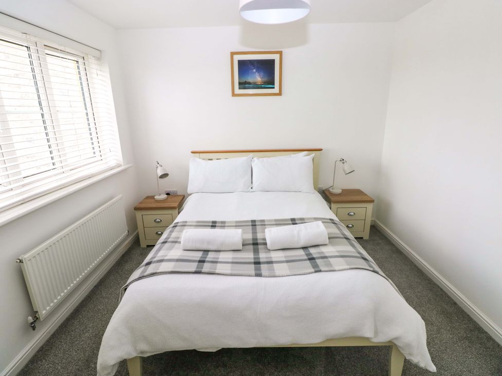 A bedroom with a bed and bedside table at 69 Ffordd Y Meillion in Llanelli