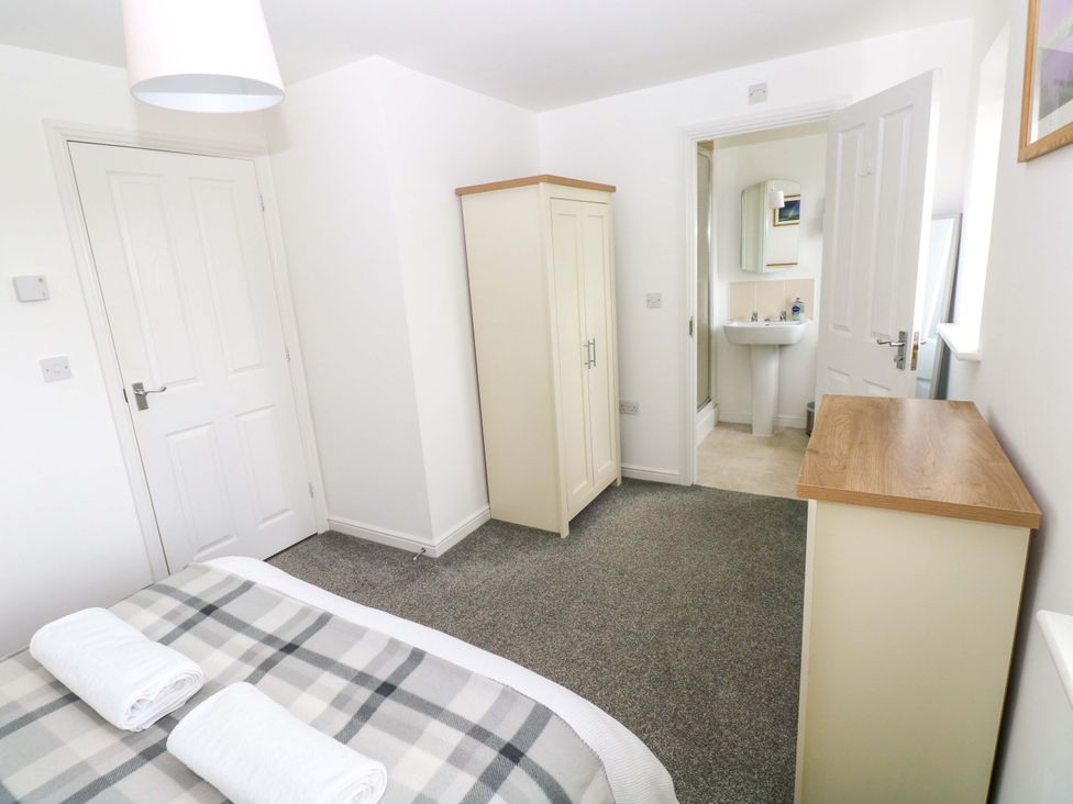 A bedroom with a bed and wardrobe at 69 Ffordd Y Meillion in Llanelli