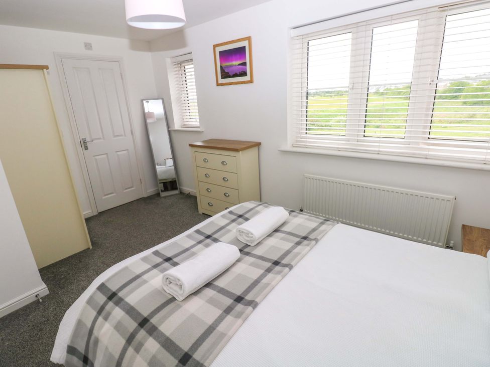 A bedroom with a bed and a dresser at 69 Ffordd Y Meillion in Llanelli