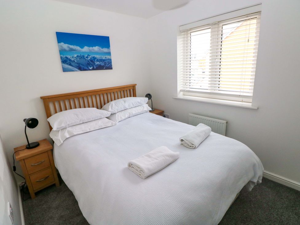 A bedroom with a bed and nightstand at 69 Ffordd Y Meillion in Llanelli