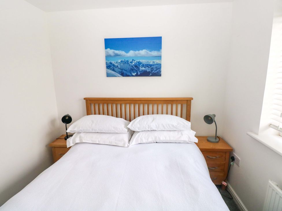 A bedroom with a bed and bedside tables at 69 Ffordd Y Meillion in Llanelli