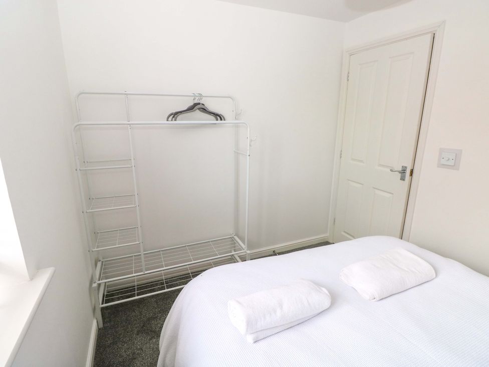 A bedroom with a bed and clothing rack at 69 Ffordd Y Meillion in Llanelli