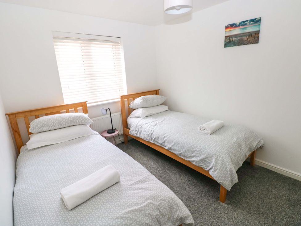 A bedroom with two single beds and a window at 69 Ffordd Y Meillion in Llanelli