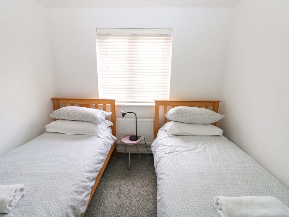 A bedroom with two single beds and a window at 69 Ffordd Y Meillion in Llanelli