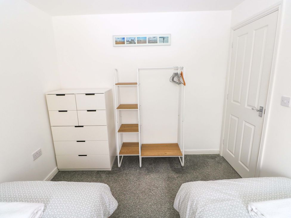A bedroom with a dresser and a clothes rack at 69 Ffordd Y Meillion in Llanelli