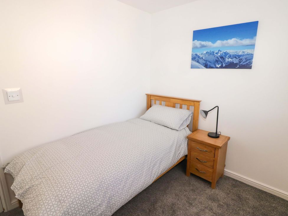 A bedroom with a bed and nightstand at 69 Ffordd Y Meillion in Llanelli