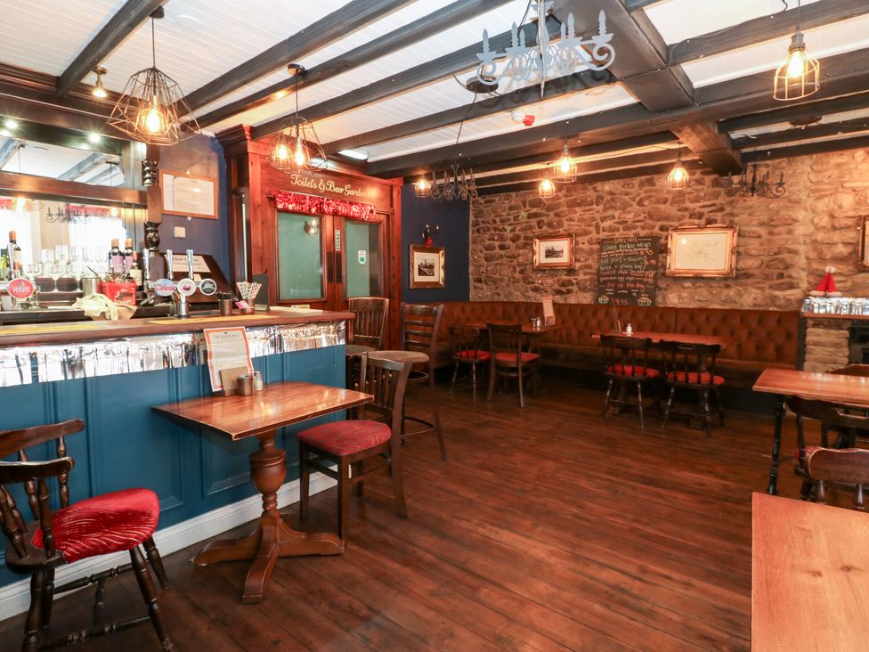 A bar with wooden furniture and a chalkboard at The Old Barn in Bishop Auckland
