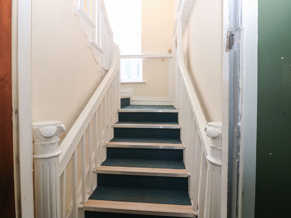 A staircase with blue carpet and white handrails at Bedroom 3 in Bishop Auckland