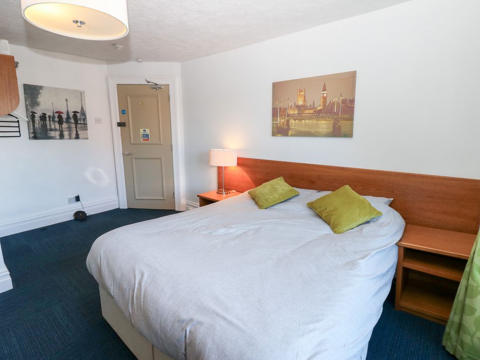 A bedroom with a bed, lamp, and wall art at Bedroom 3 in Bishop Auckland