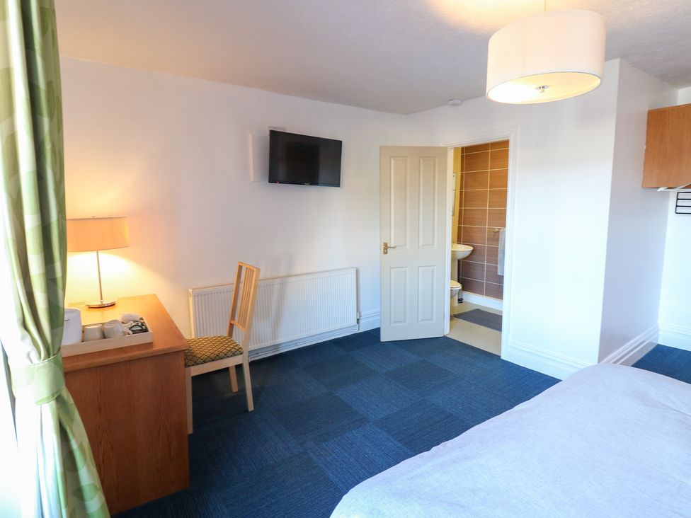 A bedroom with a bed, desk, and television at Bedroom 3 in Bishop Auckland