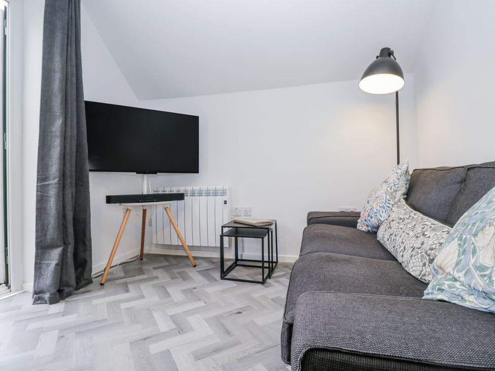 A living room with a sofa and a TV at Claife Flights in Bowness-On-Windermere