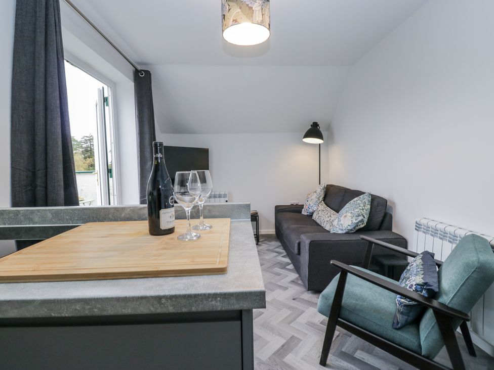 A living room with a sofa and wine glasses at Claife Flights in Bowness-On-Windermere