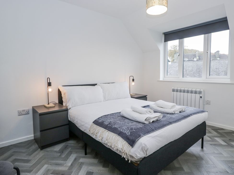 A bedroom with a bed and bedside table at Claife Flights in Bowness-On-Windermere