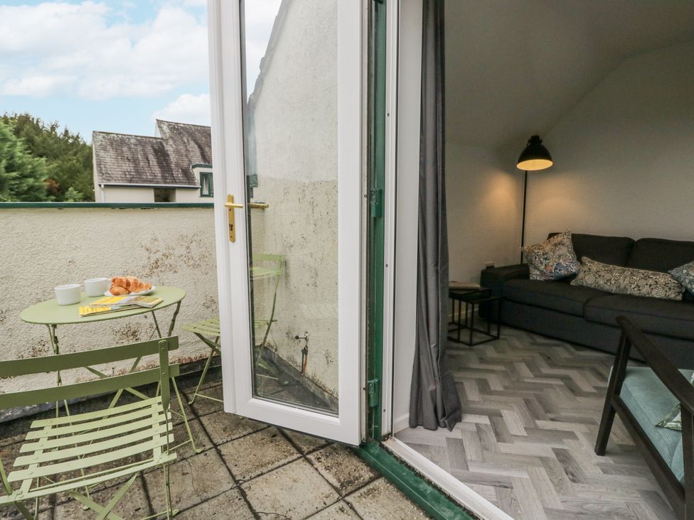 A balcony with a green table and chairs at Claife Flights in Bowness-On-Windermere