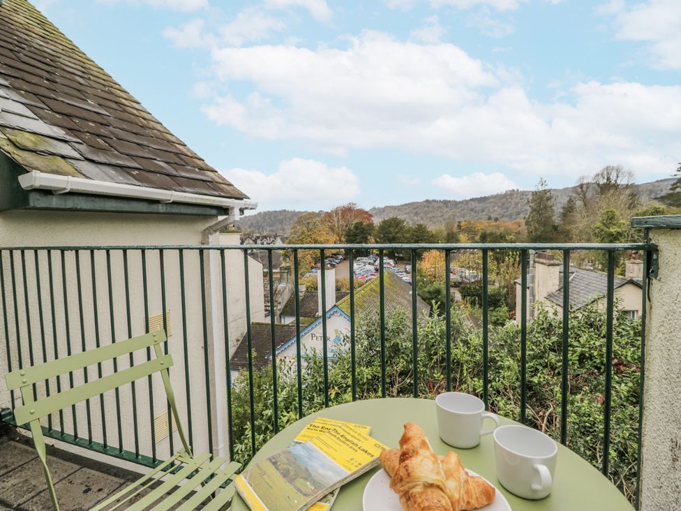 An outdoor terrace with a table, croissant, and coffee cups at Claife Flights in Bowness-On-Windermere