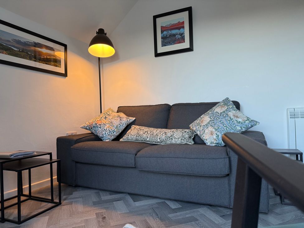 A living room with a sofa, pillows, lamp and picture frames at Claife Flights, Bowness-On-Windermere