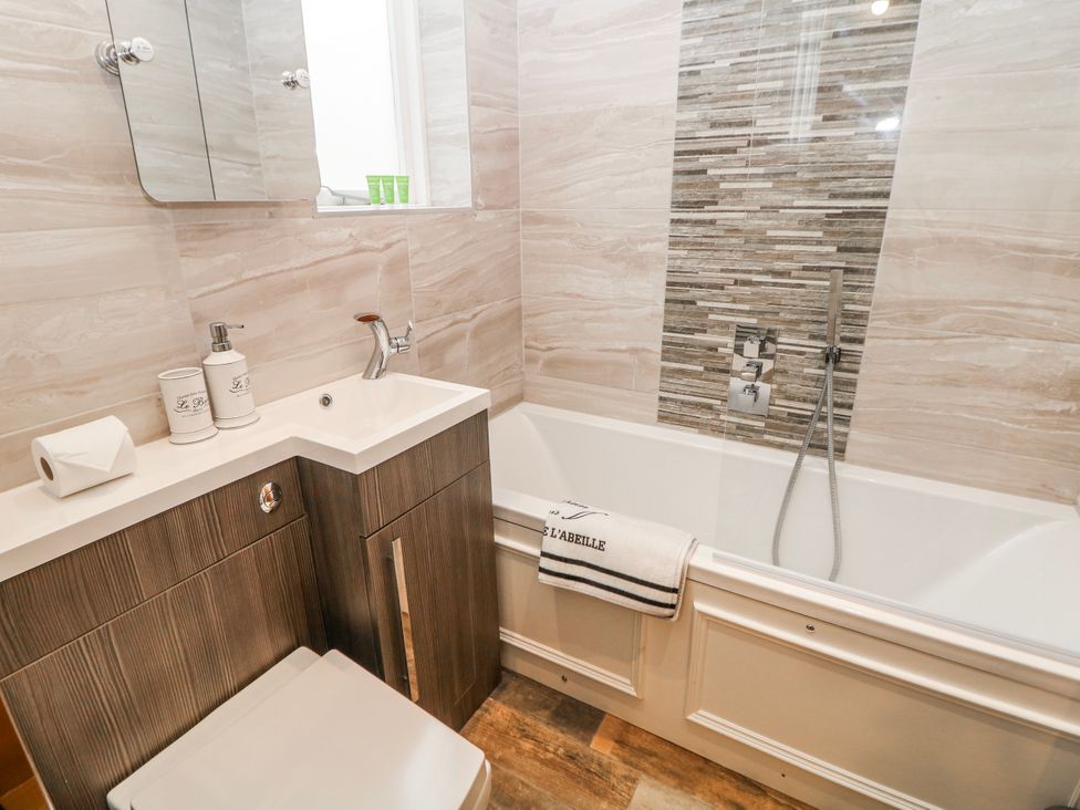 A bathroom with a bathtub, vanity, and toilet at High Tor (84) Studio Matlock