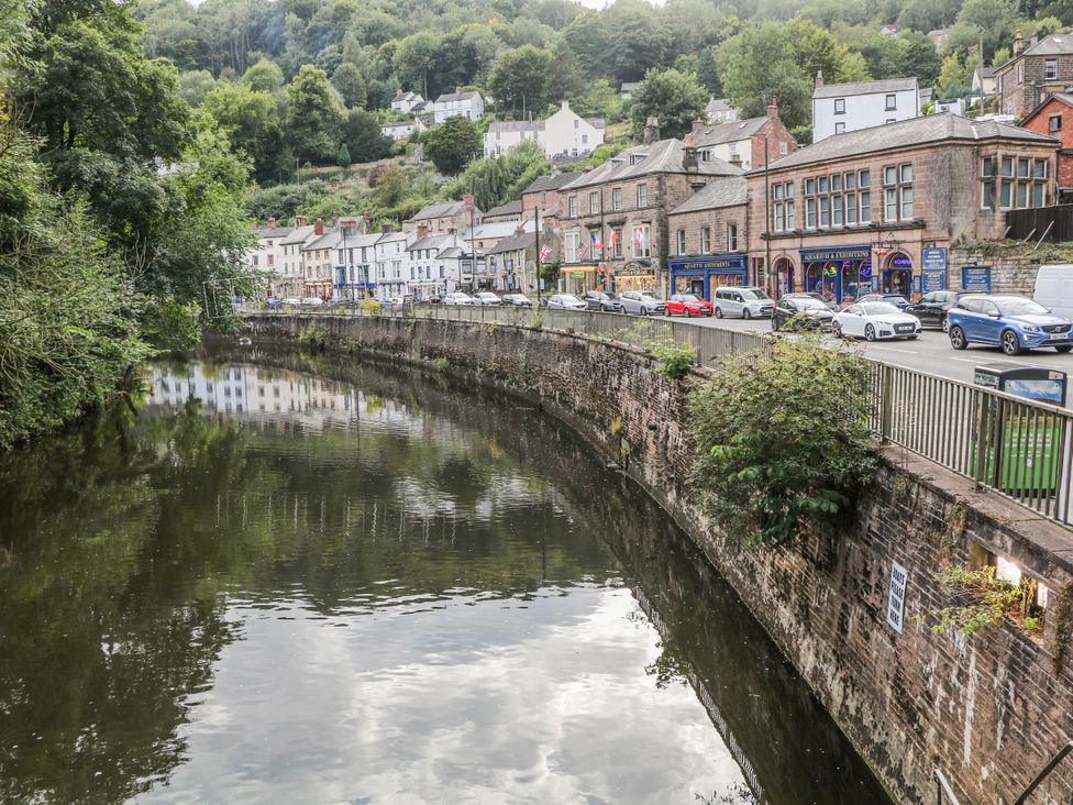 A view of a river with buildings and cars alongside at High Tor (84) Studio in Matlock