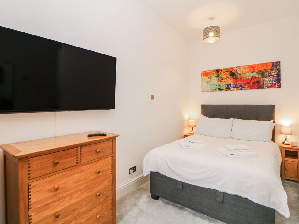 A bedroom with a bed, television, and wooden furniture at Riber in Matlock Bath