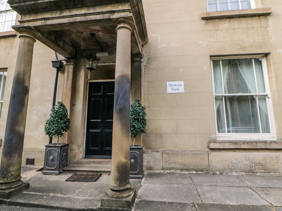 The entrance of a building with columns and a sign at Derwent View in Matlock