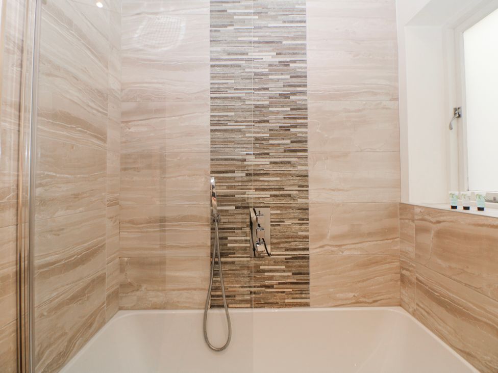 A bathroom with a bathtub and showerhead at Arkwright in Matlock