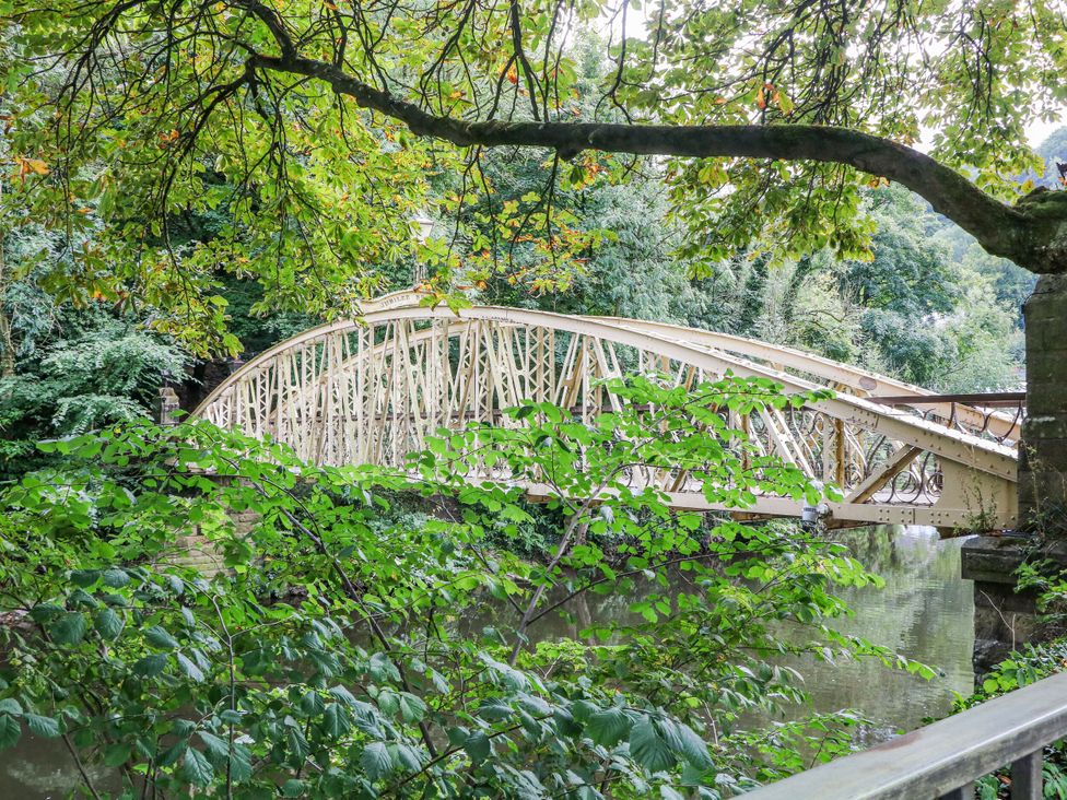 A bridge over water surrounded by trees and leaves in Matlock Bath