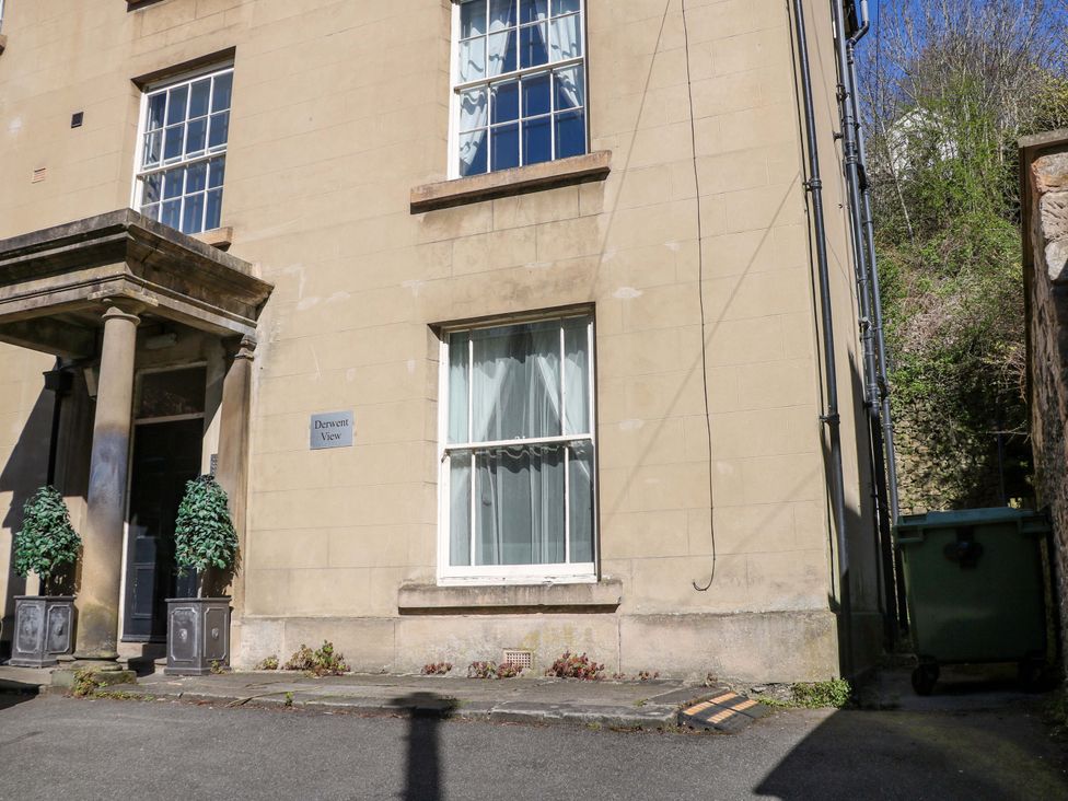 An outdoor view of a building facade with a window and sign at Derwent View, Matlock Bath