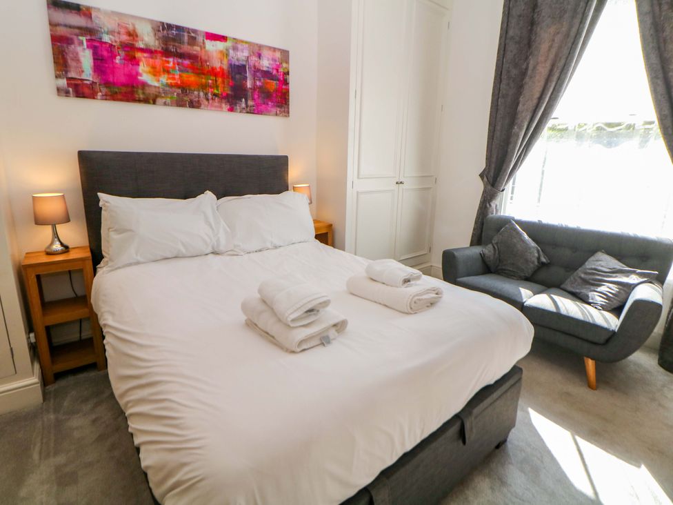 A bedroom with a bed and armchair at Lumsdale in Matlock Bath