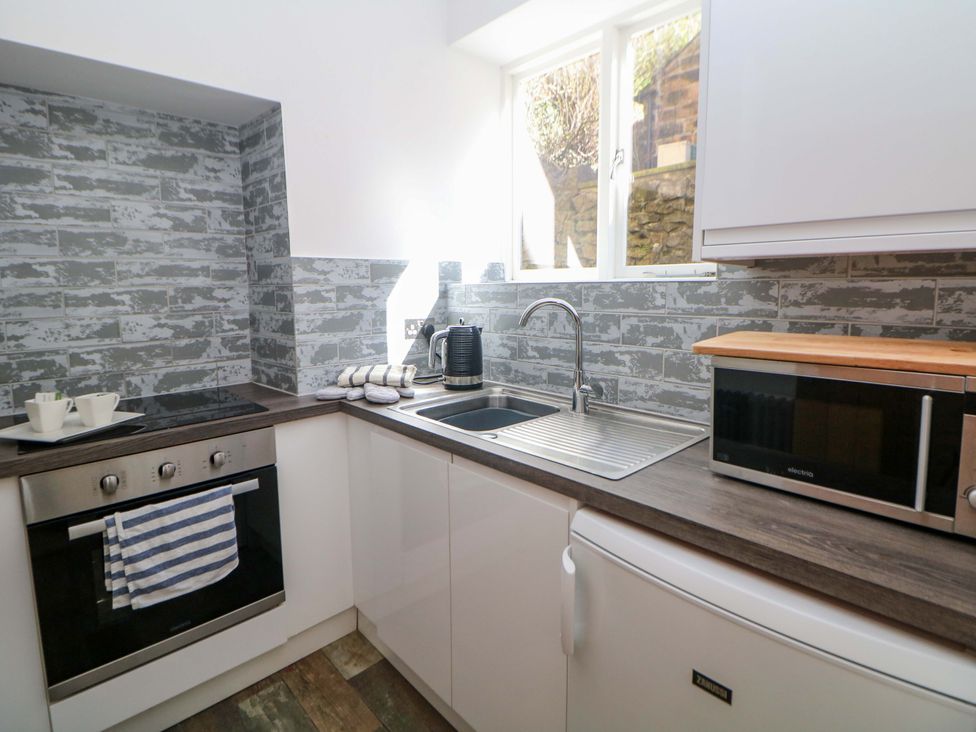 A kitchen with an oven, sink, and microwave at Lumsdale in Matlock Bath