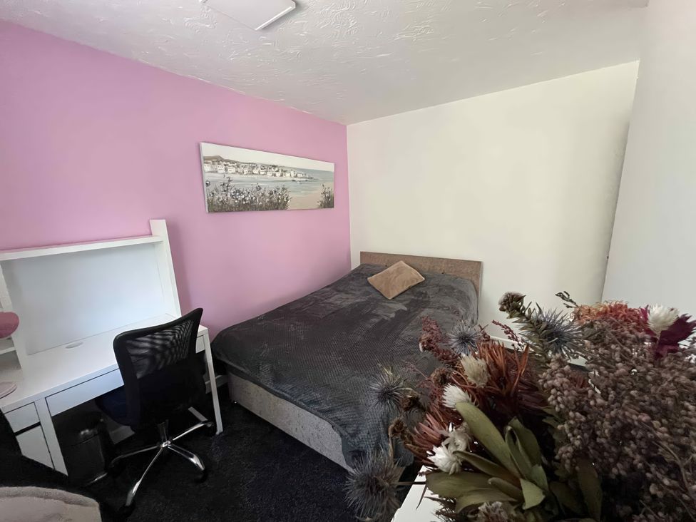 A bedroom with a bed and desk at 37 Hanbury Gardens in Colchester