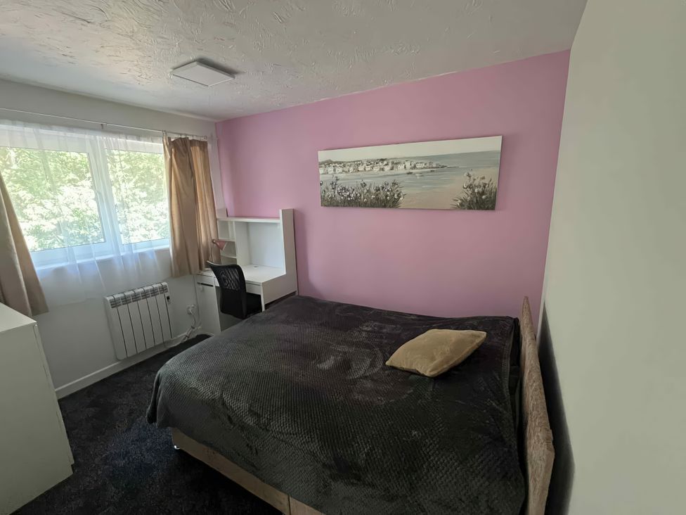 A bedroom with a bed, desk, and window at 37 Hanbury Gardens Colchester