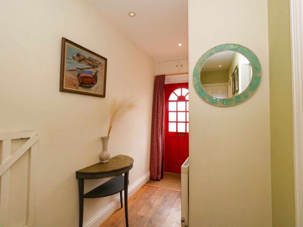 A hallway with a table and a painting at Garden Retreat in Swanage