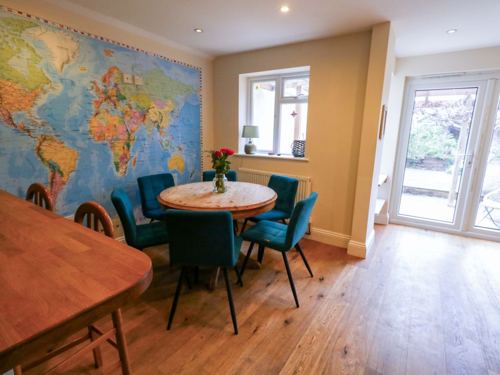 A dining room with a round table and chairs at Garden Retreat in Swanage
