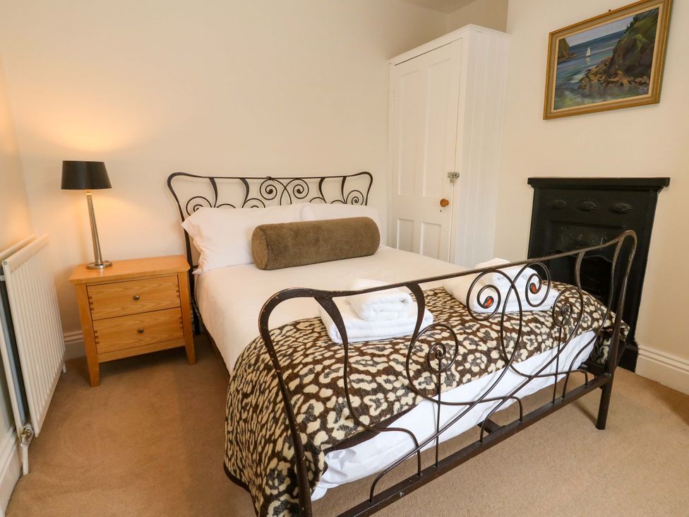 A bedroom with a bed and a nightstand at Garden Retreat in Swanage