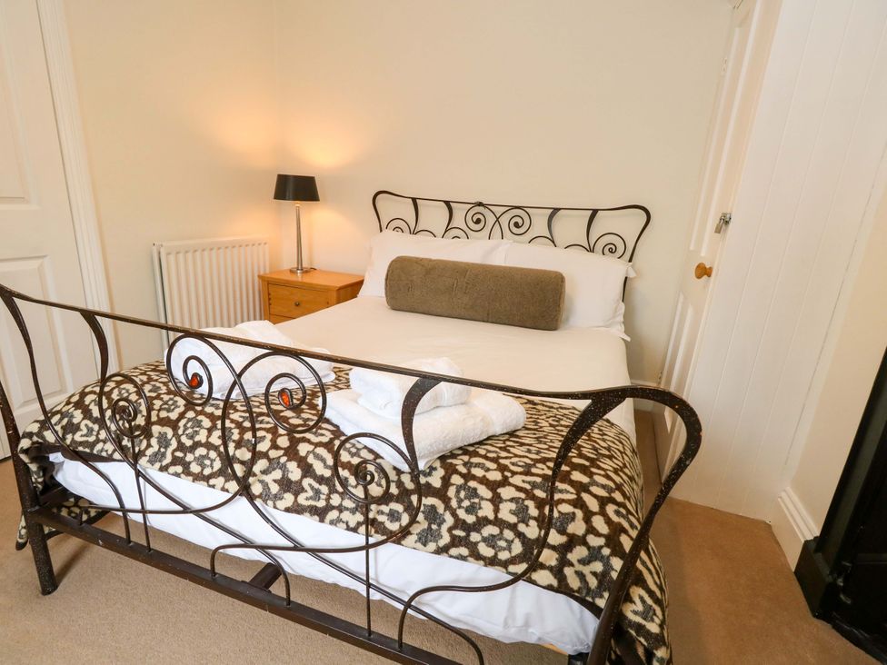 A bedroom with a bed and bedside lamp at Garden Retreat in Swanage