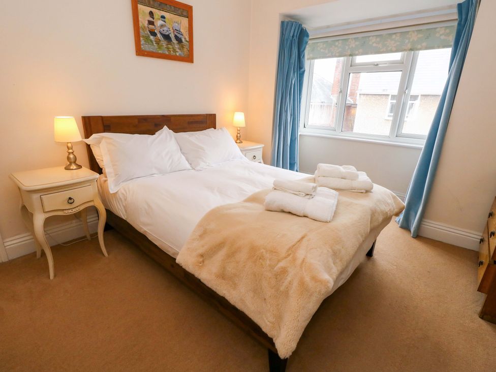 A bedroom with a bed and bedside tables at Garden Retreat in Swanage