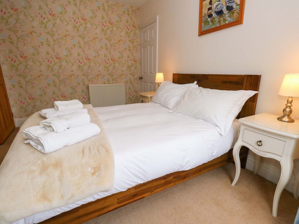 A bedroom with a bed and bedside table at Garden Retreat in Swanage