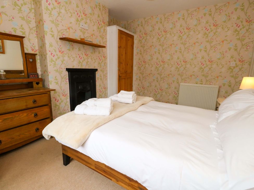 A bedroom with a bed and dresser at Garden Retreat in Swanage