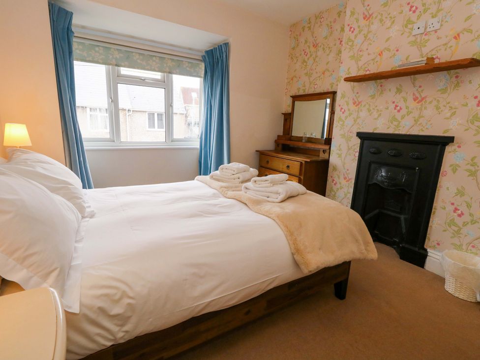 A bedroom with a bed and dresser at Garden Retreat in Swanage