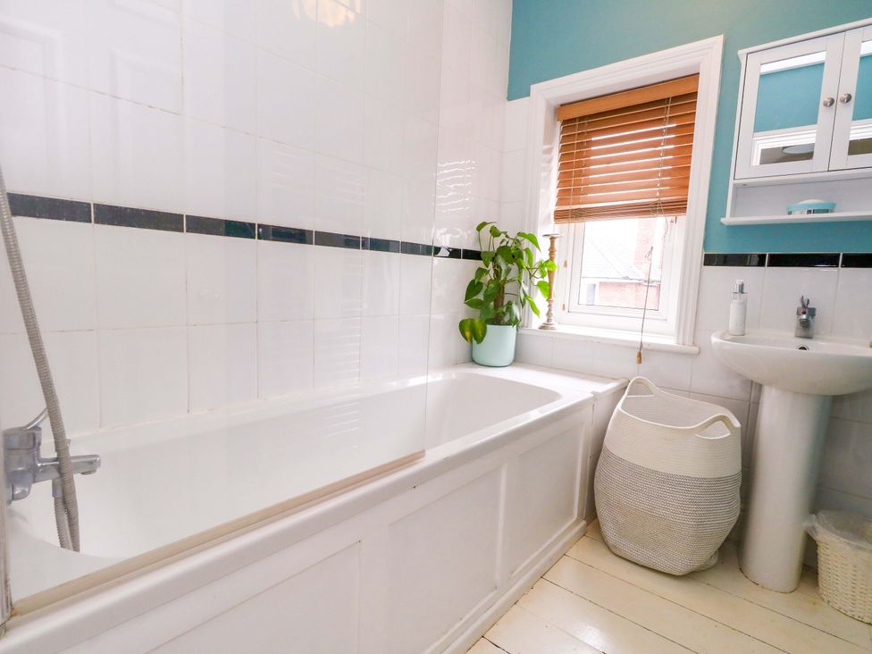 A bathroom with a bathtub and sink at Garden Retreat in Swanage