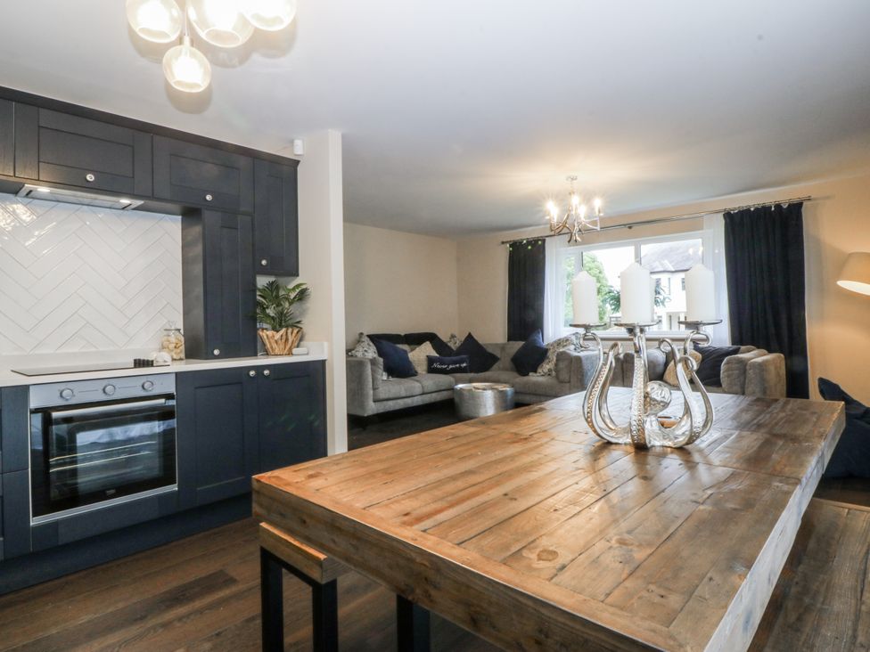 A kitchen and living room area with a dining table and couch at Tyn Y Coed