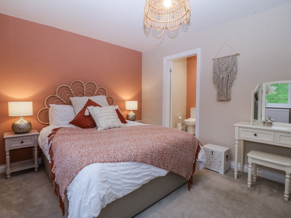 A bedroom with a bed and vanity at Tyn Y Coed