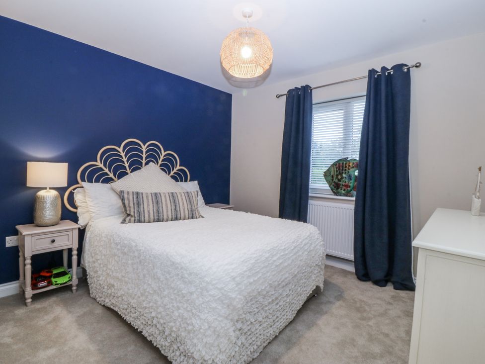A bedroom with a bed and a lamp on a nightstand at Tyn Y Coed 