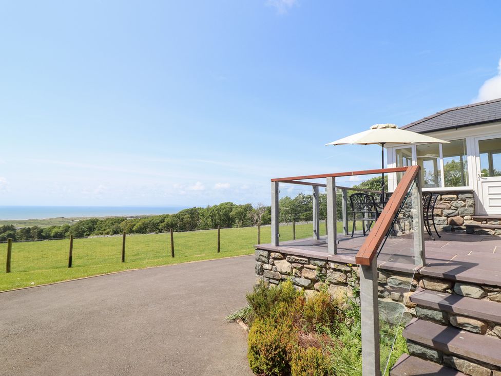 A patio area with furniture overlooking a field at Ysgubor Newydd Parc Isaf Dyffryn Ardudwy