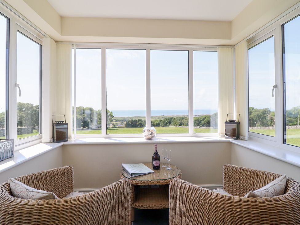 A conservatory with a view overlooking the sea at Ysgubor Newydd Parc Isaf Dyffryn Ardudwy