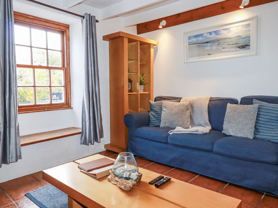 A living room with a sofa and coffee table at Rose Cottage in Falmouth
